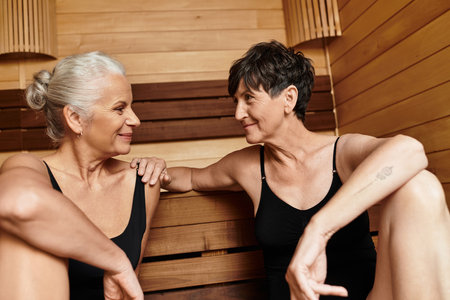 Mature women relax and bond in a wellness center, embracing their love and connection.の写真素材