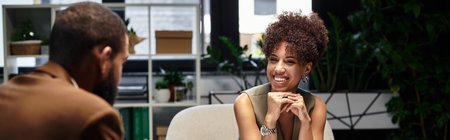 Young woman smiles and engages in discussion with a man during a interview in an studio.の写真素材