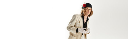 A young handsome man showcases a chic, feminine look adorned with striking fashion elements.