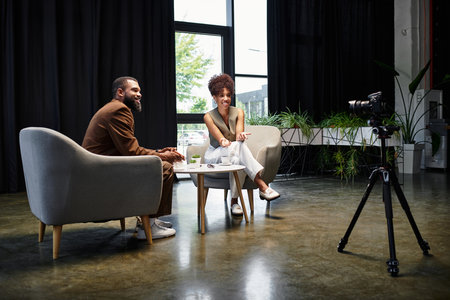 Two young professionals confidently connect in a bright studio during a interview.