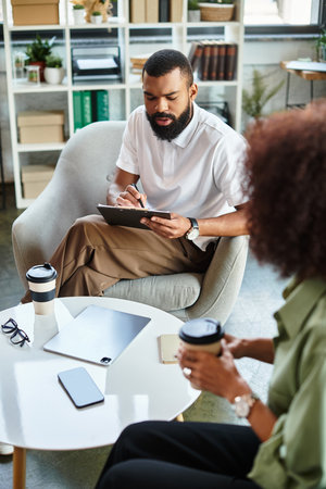 A man and woman participate in a interview, conducting interview in a bright studio.の写真素材