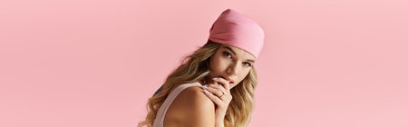 Fashionable young woman in pink hat playfully poses, showcasing her beauty and vibrant style.の写真素材