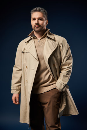 Handsome man poses confidently in a chic studio wearing a fashionable ensemble.の写真素材