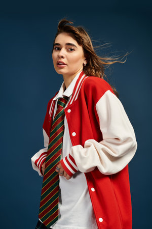 A beautiful young woman stands confidently in a colorful outfit, showcasing elegance and youth.