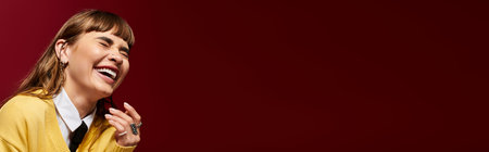 A young woman with a radiant smile enjoys a lighthearted moment, embodying happiness and vitality.の写真素材