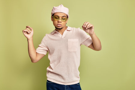 A fashionable young African American man displays his trendy style while dancing playfully.の写真素材