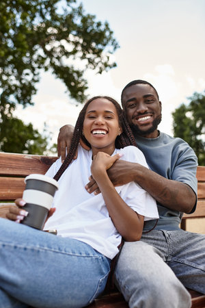 A young couple strolls hand in hand, sharing smiles and warmth in the vibrant outdoors.