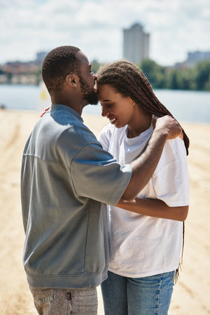 A couple walks closely together, sharing warm smiles as they enjoy a beautiful day outdoors.