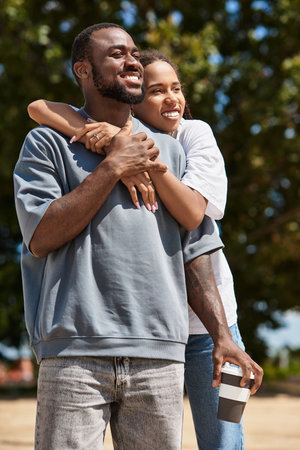 A young couple shares a joyful moment while walking outdoors, wrapped in love and happiness.