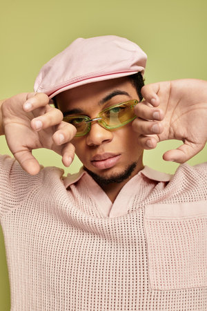 A fashionable young african american man showcases his trendy pink polo and flat cap style.の写真素材