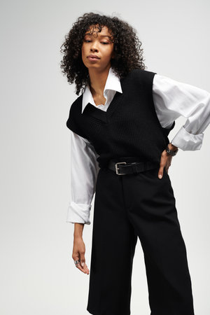 A young woman showcases poise and elegance while wearing chic business attire, exuding confidence.の写真素材