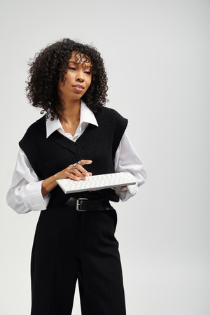 Young beautiful woman poses gracefully in stylish business attire, exuding elegance and poise.の写真素材