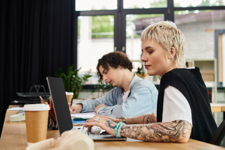 Young individuals are diligently working at their desks in a stylish office, showcasing teamwork.