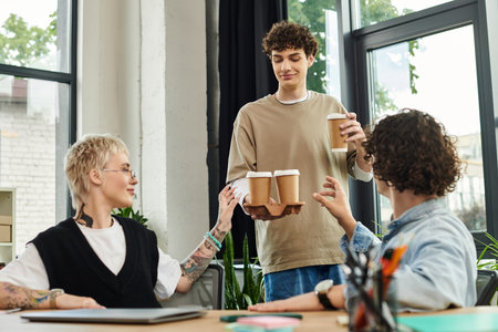 In a bright and spacious office, young workers engage in dynamic teamwork while enjoying drinks.
