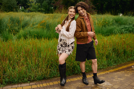 A young couple joyfully strolls through a beautiful park, sharing love and laughter.の写真素材