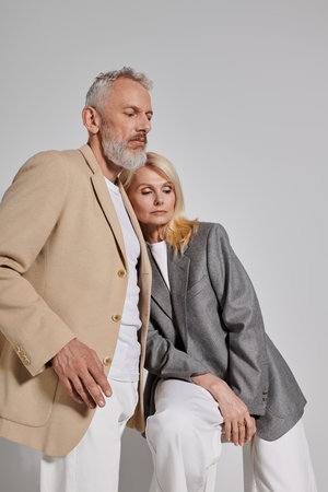 A stylish senior couple embraces, radiating love and warmth with gentle smiles.の写真素材