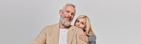 A loving senior couple embraces, showcasing their romance and connection in stylish outfits.