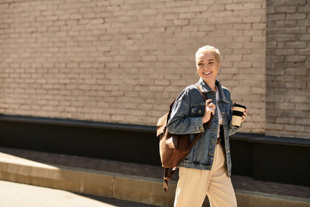 A cheerful young woman strolls through an urban area, embracing the vibrant atmosphere around her.の写真素材