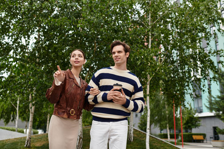 A young couple enjoys each others company while walking through a vibrant park, positively engaged.
