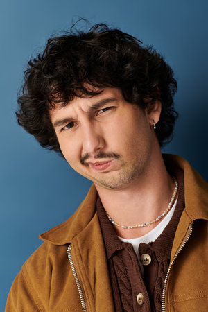 Stylish young man grabs attention with his trendy outfit and unique expression.