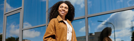 A stylish African American woman showcases her autumn outfit against a modern setting, banner