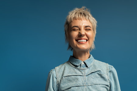 A young woman with a unique fashion sense smiles joyfully against a stunning backdrop.