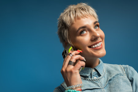 A stylish young woman with short hair joyfully chats, radiating charm.