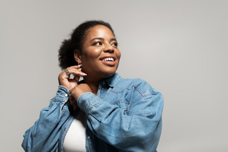 A confident plus size woman in trendy autumn attire enjoys posing in a studio, exuding style.