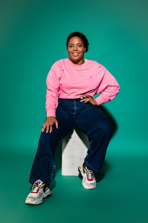 A confident plus-size Black woman poses in a stylish autumn outfit, exuding body positivity.