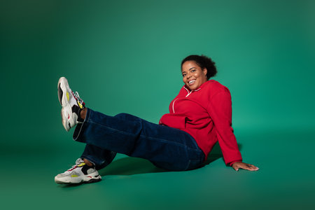 A confident plus size woman poses in a trendy autumn outfit, highlighting her style and comfort.