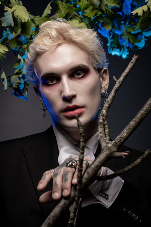 A young handsome man displays an epic Halloween costume with dramatic makeup and accessories.のeditorial素材