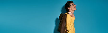 Handsome young man in a yellow sweater smiles.の写真素材