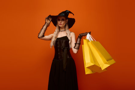 Witch with long hair and hat holds shopping bags, embracing the joy of Halloween festivities.