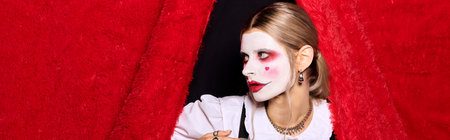 A young woman showcases her Halloween costume with striking makeup in a fun and festive setting.