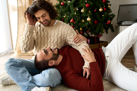 A loving gay couple enjoys quality time at home, surrounded by holiday decor and warmth.