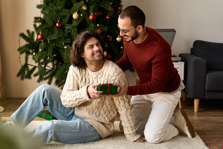 Two men share a heartfelt moment exchanging gifts at home, filled with laughter and warmth.