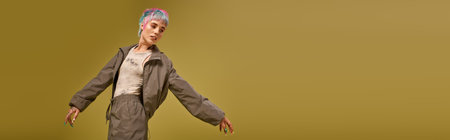 A young woman poses confidently in a studio with colorful, dyed hair and trendy attire, banner