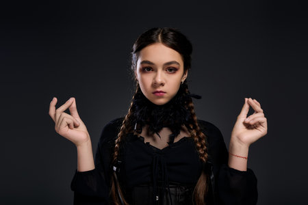 A young girl with braids poses in a gothic dress for Halloween, embodying her spooky Wednesday...