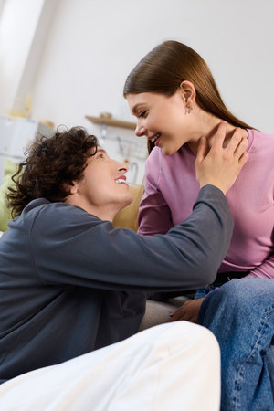 Joyful couple enjoys a loving exchange while sitting comfortably in their modern living space.
