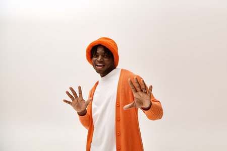 Young man in a bright orange outfit smiles, showcasing style and confidence.