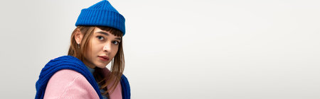 Beautiful young woman poses actively in warm, stylish attire, capturing the essence of autumn.