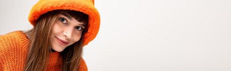 Beautiful young woman wears cozy orange attire, radiating warmth and happiness during fall.の写真素材