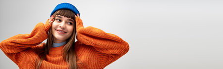 A beautiful young woman enjoys the cozy vibe of the season, posing playfully in warm attire.の写真素材