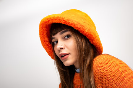 A beautiful young woman poses playfully in her stylish, warm outfit perfect for the season.