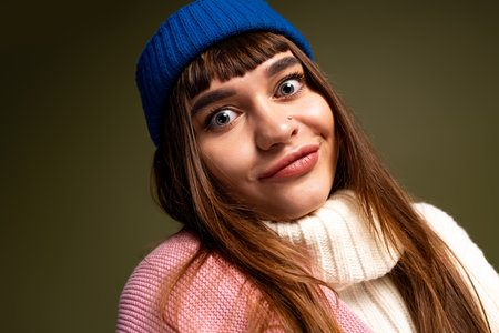 A beautiful young woman poses with enthusiasm in warm, fashionable attire during autumn.