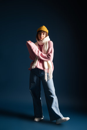A young woman poses gracefully while wearing a stylish, warm outfit suited for autumn.の写真素材