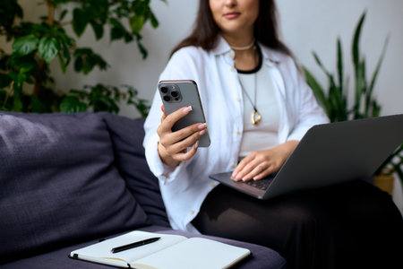 A woman with Waardenburg syndrome engages in remote work, balancing tasks at home.の写真素材