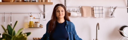 A woman with waardenburg syndrome standing in her stylish home kitchen while smiling, bannerの写真素材
