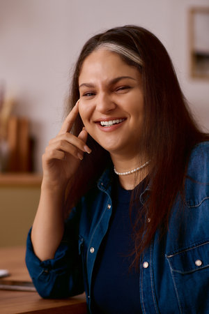 A woman with Waardenburg syndrome laughing in her bright home space.