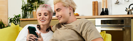 A young couple smiles together on a bright couch, enjoying a happy moment.